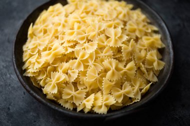 Bir kase İtalyan farfalle makarnası pişmemiş bulanık bulanık.