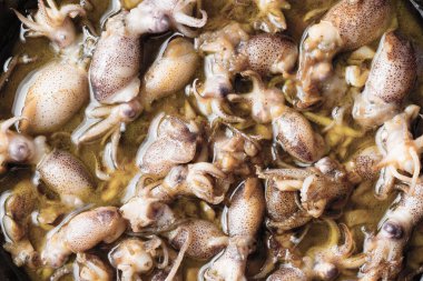 Sarımsak ve zeytinyağlı gıda arka planında kırsal yavru mürekkep balığının kapağını kapatın.      