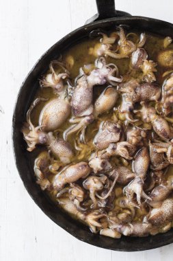 Sarımsak ve zeytinyağına bulanmış kırsal yavru mürekkep balığının kapağını kapat.          