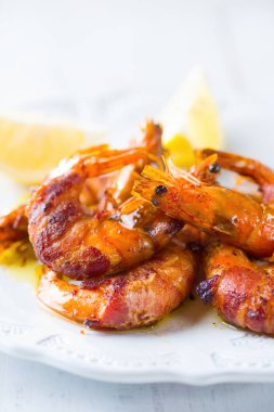 Izgara domuz pastırmasına sarılmış karides deniz ürünleri.