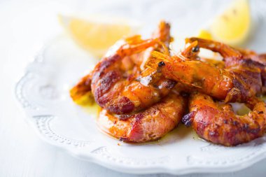 Izgara domuz pastırmasına sarılmış karides deniz ürünleri.