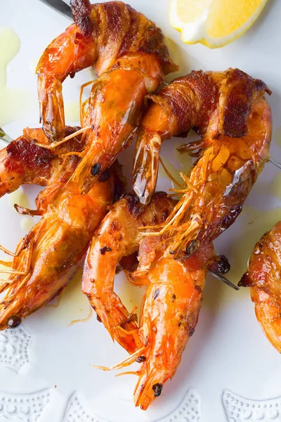 Izgara domuz pastırmasına sarılmış karides deniz ürünleri.