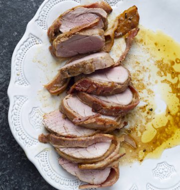 Dilimlenmiş pastırmaya sarılmış domuz filetosu. 