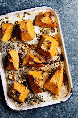 Bir tepsi rustik altın fırınlanmış balkabağı.