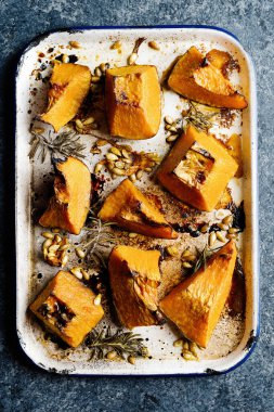 Bir tepsi rustik altın fırınlanmış balkabağı.