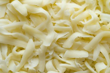 Kalın kesilmiş, rendelenmiş mozzarella peynirinin arka planını kapatın.