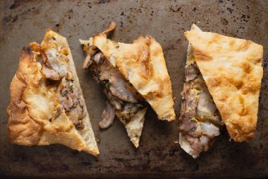 close up of italian roasted pork belly porchetta sandwich