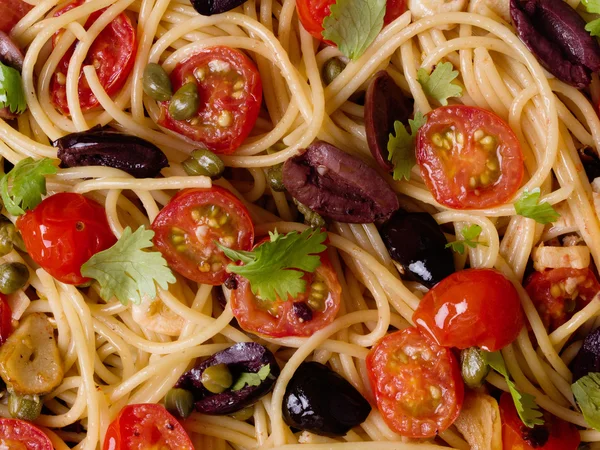 Italské špagety puttanesca těstoviny potraviny pozadí — Stock fotografie