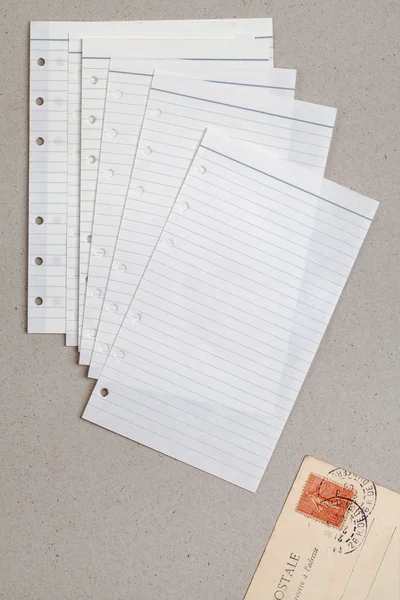 Clean sheet of lined notebook and a postcard — Stock Photo, Image
