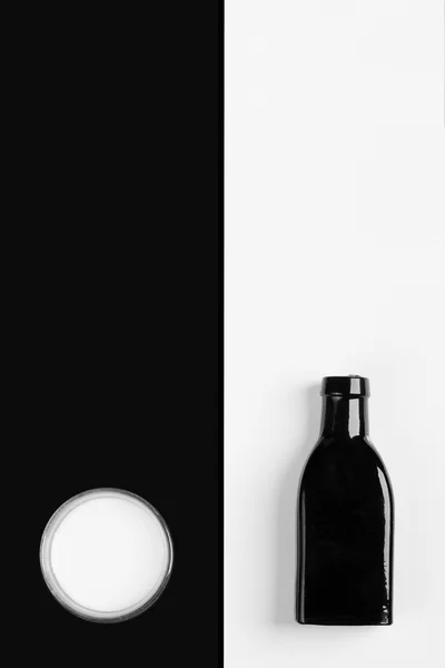 Vintage little black bottle and beaker of milk — Stock Photo, Image