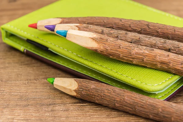 Lápices de madera de colores y libro de trabajo de cuero marrón verde —  Fotos de Stock