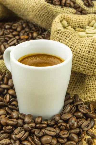 Frischer Espresso und grüne Kaffeebohnen im Jutebeutel — Stockfoto