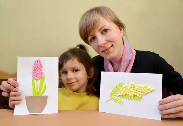 The young woman with the little daughter show self-made cards in — Stock Photo, Image