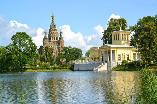 PETERHOF, RÚSSIA - JULHO 24, 2015: Uma vista de uma catedral de Santos Pyotr e Pavel e Tsaritsyn o pavilhão na margem de Holguin de um pon — Fotografia de Stock