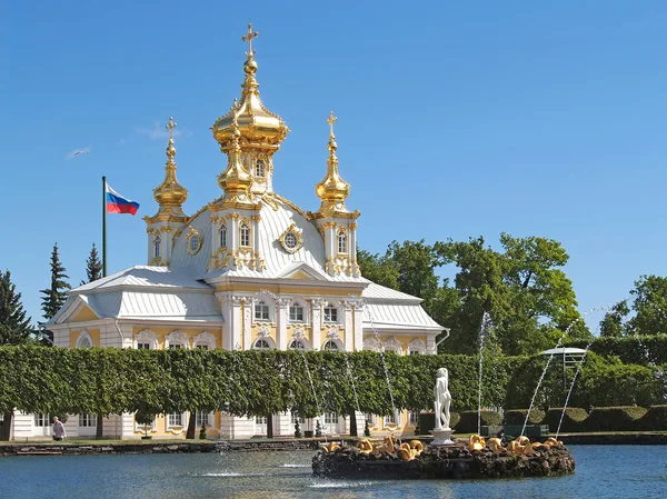 PETERHOF, RUSSIA - JUNE 11, 2008: Fountains of square ponds against Church of Saints Peter and Paul — Stock Photo, Image