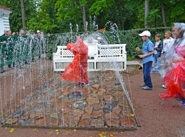PETERHOF, RUSSIA - JULY 24, 2015: The Bench fountain cracker in the Monplezirsky garden. Lower park clipart