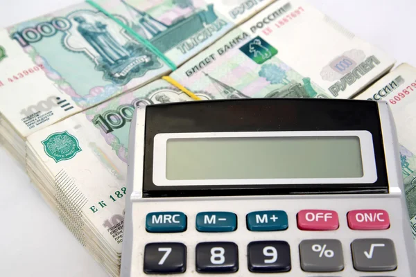 A calculadora está em pacotes de notas russas de mil rublos — Fotografia de Stock