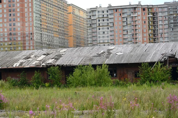 Vieux ateliers ferroviaires contre un lotissement en construction. Saint-Pétersbourg Image En Vente