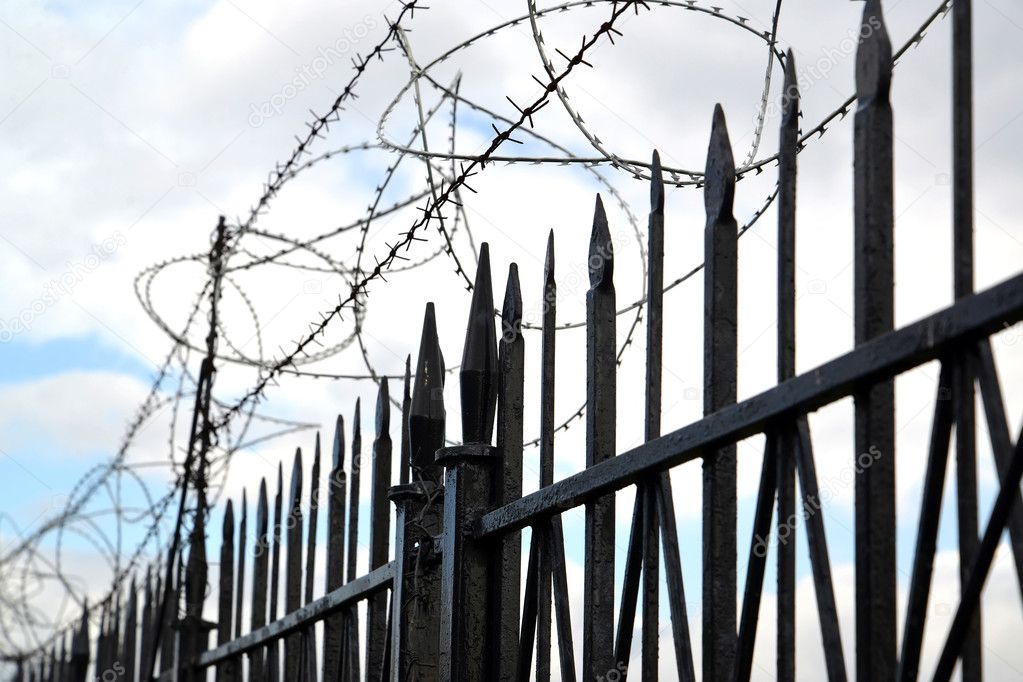 The barbed wire is tense over a metal fencing