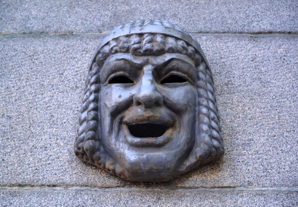 Маскарон - театральная маска на гранитной стене. Санкт-Петербург
