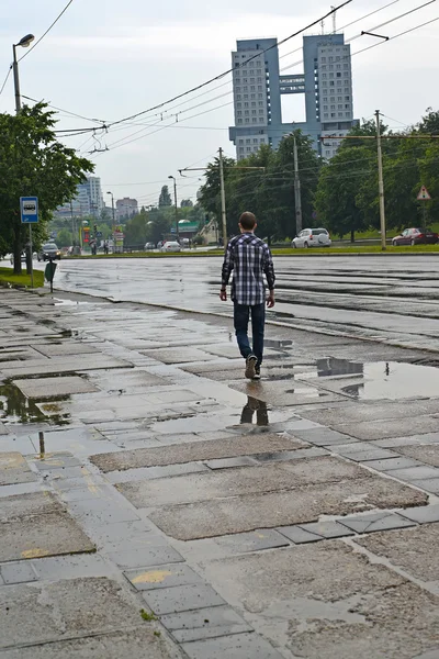 KALINININGRAD, RUSIA - 21 DE JUNIO DE 2016: La persona va a las piscinas después de una lluvia, avenida Moskovsky — Foto de Stock