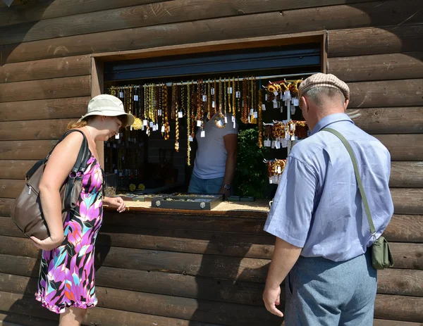 The married couple chooses amber jewelry in a booth — Stock Photo, Image