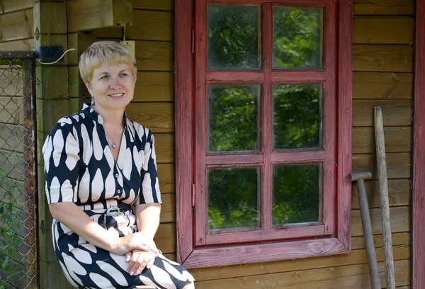 La mujer de los años medios se queda en casa sobre rural —  Fotos de Stock