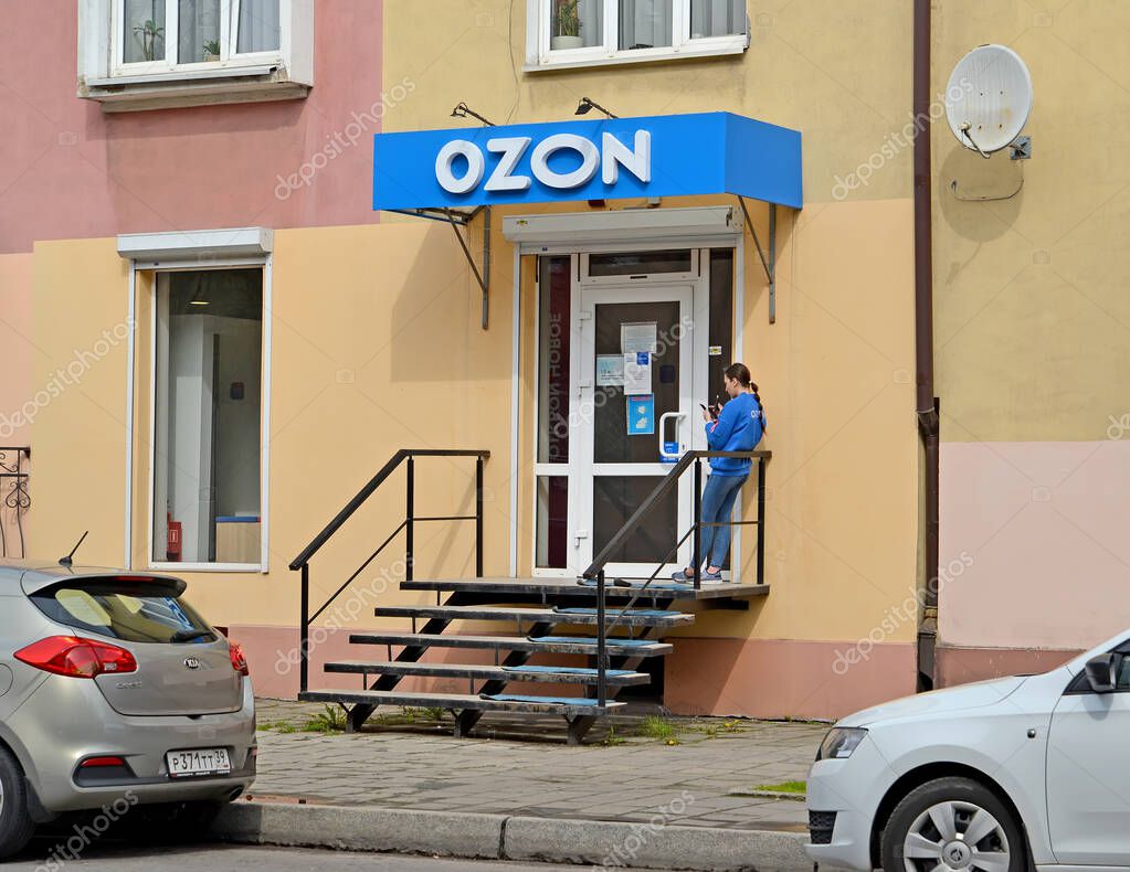 KALININGRAD, RUSSIA - MAY 04, 2021: An employee of an online store OZON stands near the front door
