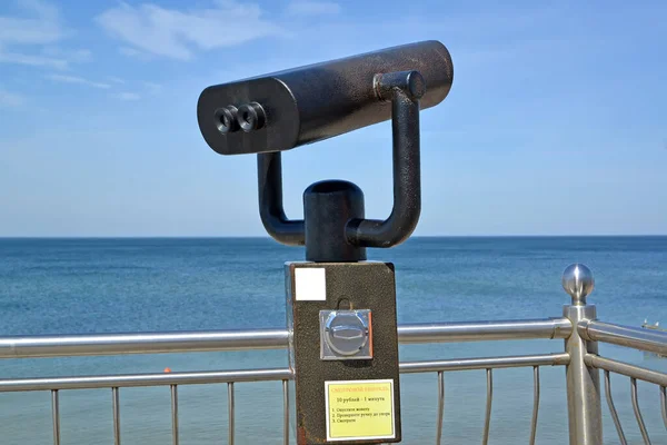 A fragment of observation binoculars against the background of the Baltic Sea. Zelenogradsk, Kaliningrad region. Russian text