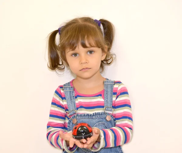 Портрет маленькой девочки с игрушкой в руках на светлой спине — стоковое фото