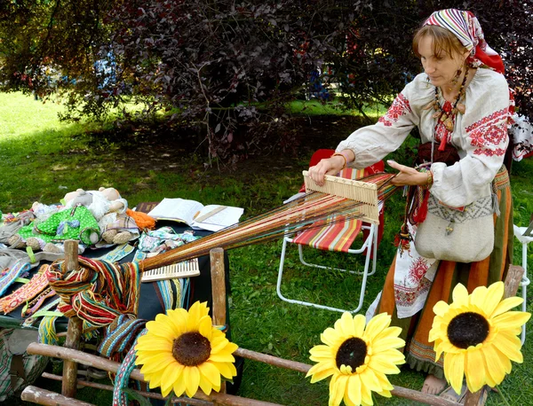 Le tisserand en costume national fonctionne (se concentrer sur les mains ) — Photo