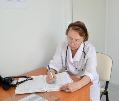 Doktor terapist oturuyor magazine, çalışma doldurur 