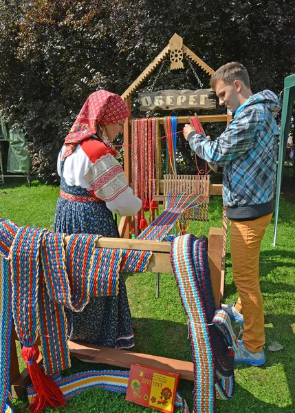 Der Weber lehrt den jungen Mann, das Hilfsrohr zu weben — Stockfoto