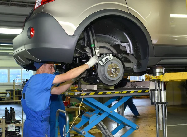 Los trabajadores establecen bastidores de depreciación en el coche. Transmisión de asamblea — Foto de Stock