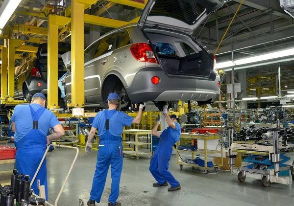 Trabajadores en el transportador de montaje de la planta de automóviles — Foto de Stock