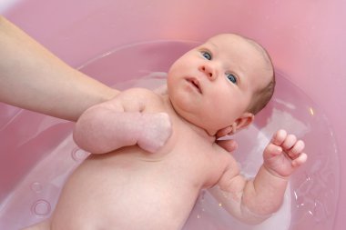 Bebeğin pembe bir tepsi içinde banyo