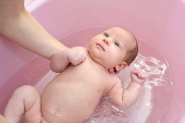 Bebeğin pembe bir tepsi içinde banyo