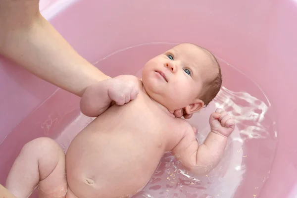 Baden van de baby in een roze lade — Stockfoto