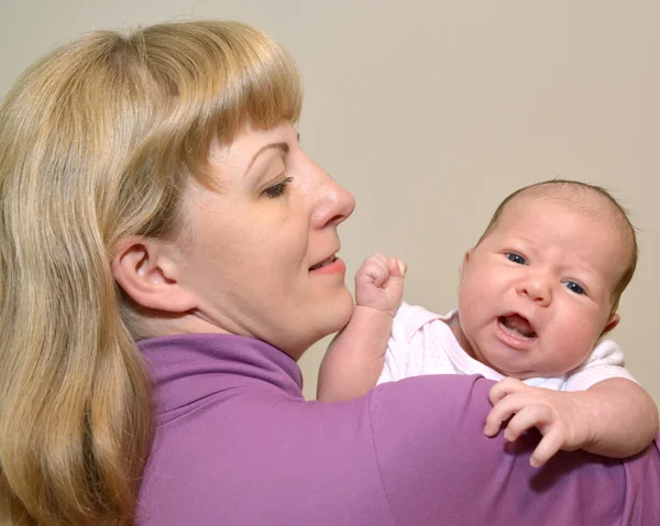 Porträtt av den unga kvinnan med barnet på händer — Stockfoto