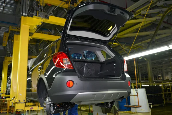 L'auto nello sguardo sospeso sul trasportatore di assemblaggio di automo — Foto Stock