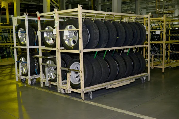 Nouvelles roues d'automobile se trouvent sur un rack dans l'atelier d'assemblage d'automobi — Photo