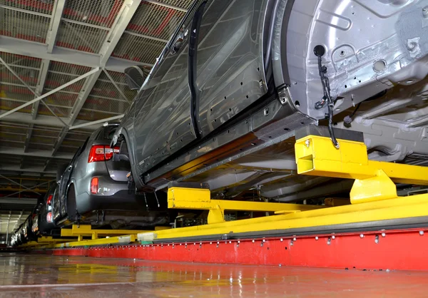 Los coches están en la línea de transporte de la tienda de montaje. Automóvil pla — Foto de Stock