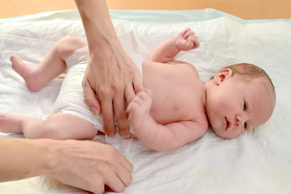 La mujer viste al bebé con un pañal —  Fotos de Stock