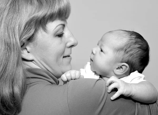 Porträtt av den unga kvinnan med barnet på händer — Stockfoto