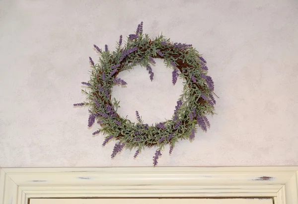 Lavendel kransen hänger på en vägg över en vit dörr — Stockfoto