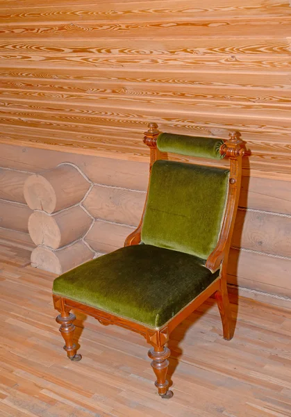 The soft chair with a velvet upholstery stands near a timbered w — Stock Photo, Image