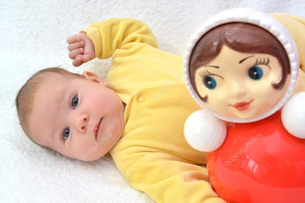 The baby's portrait with a doll tumbler toy on a white backgroun