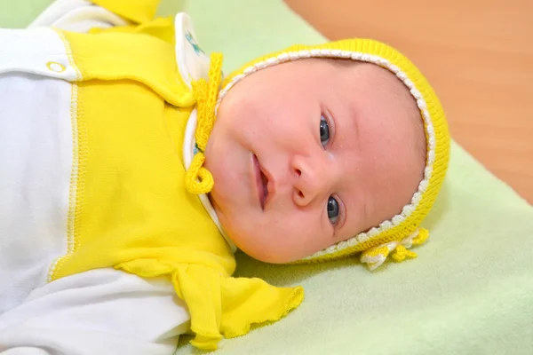 Retrato do bebê em uma tampa amarela — Fotografia de Stock