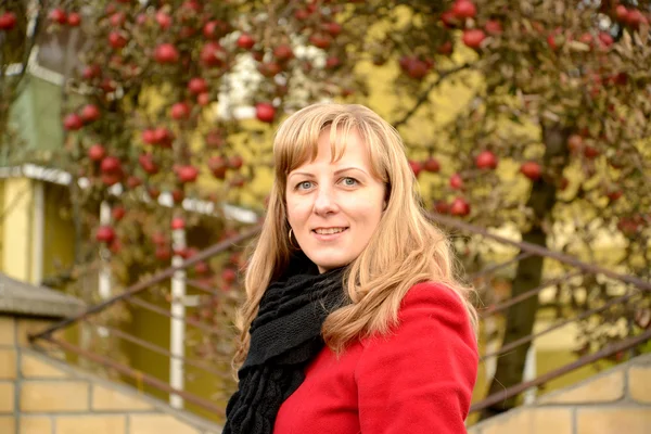 Die junge Frau gegen einen Apfelbaum mit roten Äpfeln — Stockfoto