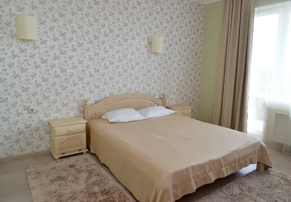 Bir çift otel odasında bir çift kişilik yatak ile hafif tonları iç — Stok fotoğraf